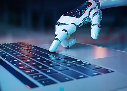 Roboterhand tippt auf einer Laptop-Tastatur