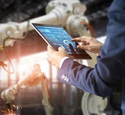 Geschäftsmann steuert Industrieroboter per Tablet
